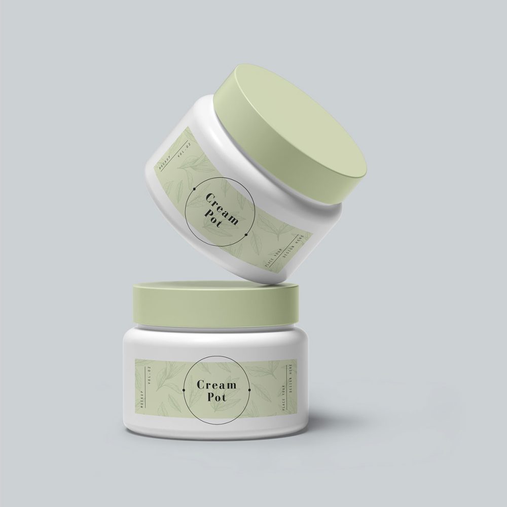 Two white jars with green lids stacked on top of each other.