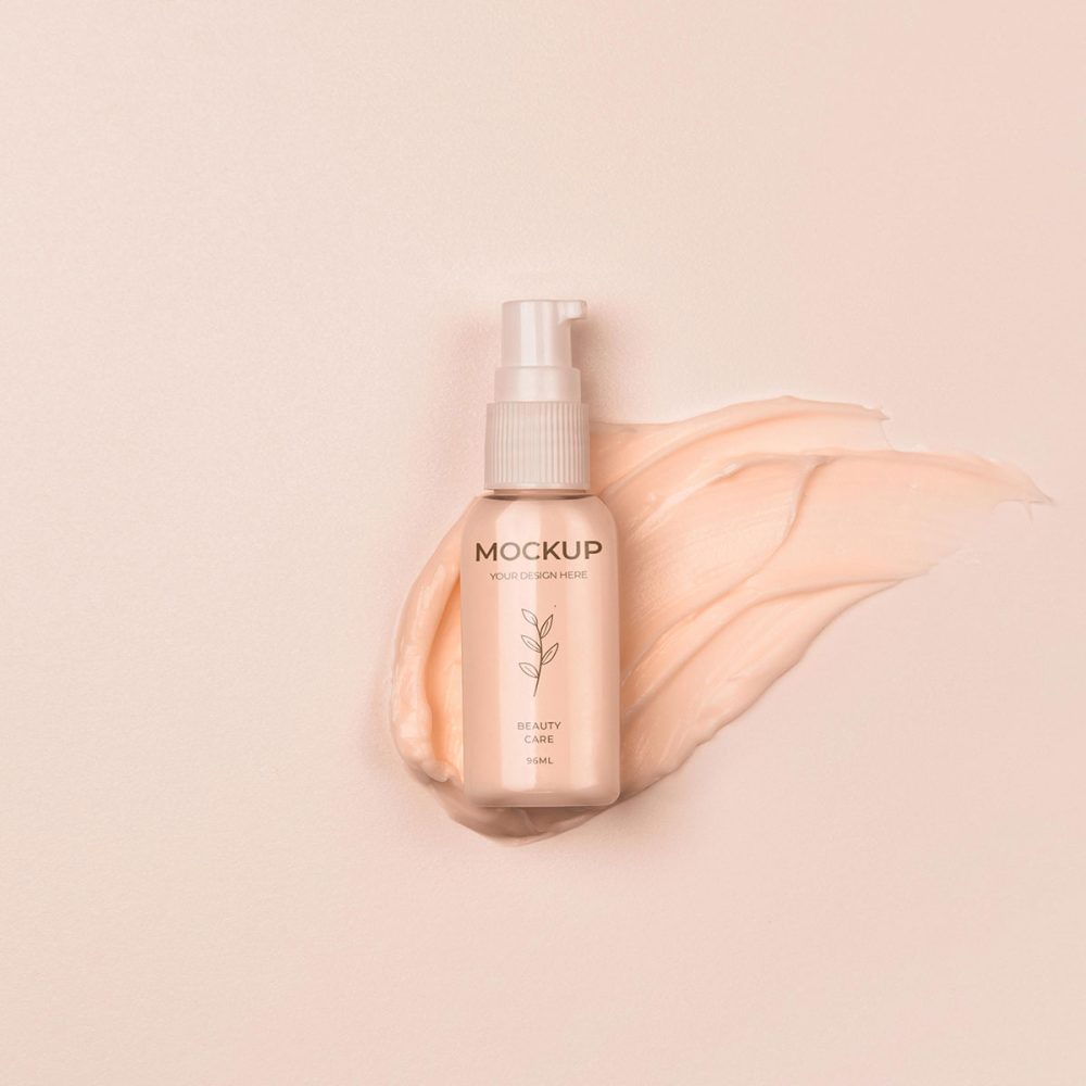 A bottle of makeup on top of some pink liquid.